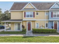 Two-story townhome with covered entry,red door, and landscaped yard at 4012 Santa Maria # 101, Kissimmee, FL 34741