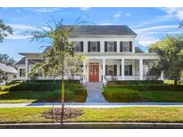 Two-story home with a wrap-around porch and landscaped yard at 416 Arbor Cir, Celebration, FL 34747