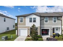 Two-story townhome with attached garage and small front yard at 445 Madison Dr, Davenport, FL 33837