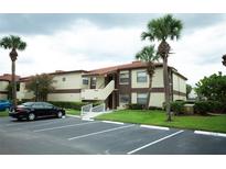 Two-story condo building with palm trees and parking at 3218 Candle Ridge Dr # 103, Orlando, FL 32822