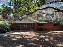 Brick ranch house with mature landscaping and large oak trees at 3800 Lavender Way, Casselberry, FL 32707