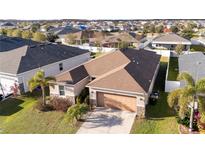 Aerial view of a single-Gathering home with a brown roof and landscaped yard at 4563 Orchard Grove Rd, Saint Cloud, FL 34772