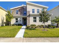 Two-story modern home with stone accents and landscaped lawn at 4633 Target Blvd, Kissimmee, FL 34746