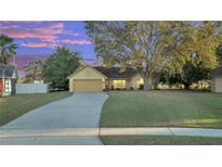 Inviting yellow house with a spacious lawn and driveway at 4814 Jeanette Ct, Saint Cloud, FL 34771