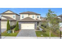 Two-story house with stone accents and a paved driveway at 7959 Delwin Ln, Kissimmee, FL 34747