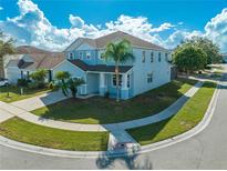 Light blue two-story home with a palm tree in the front yard and a covered lanai in the back at 1079 Berkeley Dr, Kissimmee, FL 34744