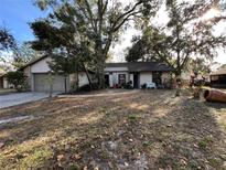 One-story house with attached garage, mature landscaping, and a paved walkway at 119 Buck Ct, Casselberry, FL 32707