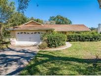 Ranch style home with attached garage and mature landscaping at 1416 Wood Lake Cir, St Cloud, FL 34772