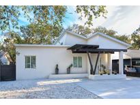 Modern white house with dark wood accents and a gravel driveway at 803 E 11Th Ave, New Smyrna Beach, FL 32169