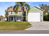 Two-story house with a large garage and landscaped lawn at 2545 Harris Blvd, Kissimmee, FL 34746