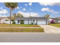 Charming single-story home with a well-maintained lawn and attached garage at 7710 Indian Ridge S Trl, Kissimmee, FL 34747