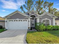Gray house with white garage door and landscaped lawn at 411 Ridge View Dr, Davenport, FL 33837