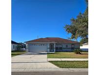 One-story house with a brown roof, attached garage, and a well-manicured lawn at 4240 Settlers Ct, St Cloud, FL 34772