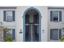 View of the building's exterior with stairs leading to the upper units at 1006 Plantation Dr # F12, Kissimmee, FL 34741