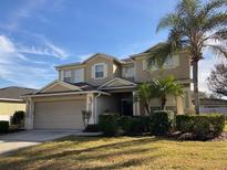 Two-story house with attached garage and landscaping at 842 Sussex Dr, Davenport, FL 33896