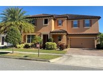 Attractive two-story home with a tiled roof, paver driveway, and landscaped yard at 8961 Lookout Pointe Dr, Windermere, FL 34786