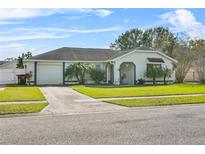 Single-story home with attached garage, driveway, and landscaped lawn at 812 Kentucky Woods E Ln, Orlando, FL 32824