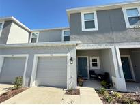 Two-story townhome with gray exterior, two-car garage, and front porch at 1861 Roosevelt Pl, Saint Cloud, FL 34769