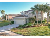Two-story house with attached garage and landscaping at 4191 Oaktree Drive, Davenport, FL 33837