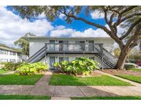 Two-story building with grey stairs and balconies, surrounded by lush landscaping at 4860 Conway Rd # 56, Orlando, FL 32812