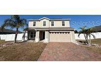 Two-story house with a brick driveway and a landscaped lawn at 640 Spanish Pine Rd, Davenport, FL 33837