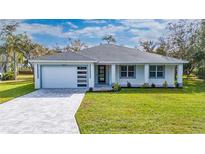 Single-story home with gray roof, white walls, and a paved driveway at 2828 Sequoyah Dr, Haines City, FL 33844