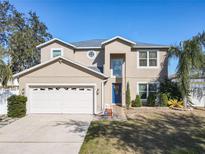 Two-story house with a neutral exterior, a three-car garage, and palm trees at 513 Big Black Way, Kissimmee, FL 34759