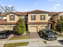 Two-story townhome with tile roof, two-car garage, and landscaping at 8121 Roseville Blvd, Davenport, FL 33896