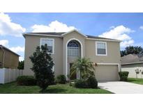 Two-story house with attached garage, landscaping, and a spacious front yard at 137 Milestone Dr, Haines City, FL 33844