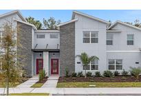 Modern two-story townhome with gray siding and red doors at 2449 Reading Trl, Kissimmee, FL 34746