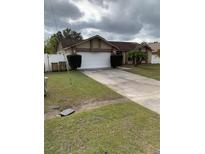 Single-story house with a two-car garage and a well-maintained lawn at 306 Medina Ct, Kissimmee, FL 34758