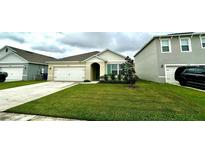 Two-story house with a white garage door and green lawn at 9657 Black Walnut Dr, Clermont, FL 34715