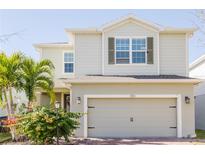 Two-story house with light beige siding, a two-car garage, and landscaping at 3112 Armstrong Spring Dr, Kissimmee, FL 34744