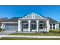 Two-story home with gray siding, white columns, and a two-car garage at 41 Marden Dr, Ormond Beach, FL 32174