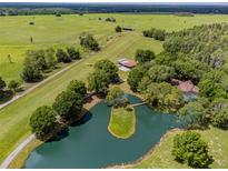 Aerial view showing home, pond, and surrounding land at 6225, 6229 Deen Still Rd, Lakeland, FL 33809