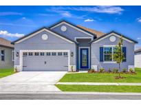 Charming one-story home with gray siding and two-car garage at 3327 Chinotto Dr, Lake Alfred, FL 33850