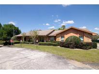 Ranch-style home with mature landscaping and circular driveway at 8723 A D Mims Rd, Orlando, FL 32818