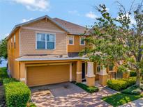 Two-story house with orange siding, a two-car garage, and lush landscaping at 625 Legacy Park Dr, Casselberry, FL 32707