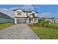 Two-story home with a gray brick driveway at 485 Adams View Ln, Auburndale, FL 33823
