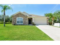 Charming one-story house with stone accents and a grassy yard at 31817 Sunpark Cir, Leesburg, FL 34748