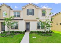 Two-story townhome with landscaped yard and walkway at 2174 Fleming Mist Pl, Kissimmee, FL 34747