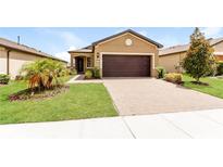 Exterior view of a charming house with a two car garage and well maintained landscaping at 406 Tortosa Ct, Davenport, FL 33837
