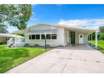 Mobile home exterior with carport and landscaping at 241 Menlo Park Ave, Davenport, FL 33897