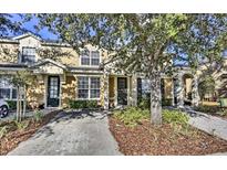 Two-story townhome with a welcoming front yard and driveway at 7663 Sir Kaufmann Ct, Kissimmee, FL 34747