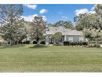 Single-story house with a gray exterior, nicely landscaped yard at 8950 Se 17Th Ct, Ocala, FL 34480