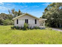 House exterior, light beige siding, black shutters, and a front porch at 2439 Lakeview St, Lakeland, FL 33801