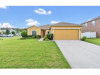 House exterior featuring a two-car garage and well-maintained lawn at 1801 Stargazer Trl, Kissimmee, FL 34758