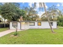 Ranch-style home with white exterior, black trim, and a green lawn at 2800 S Park Ave, Sanford, FL 32773