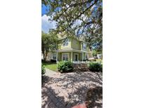 Two-story light green house with white fence at 4000 Santa Maria Dr # 108, Kissimmee, FL 34741