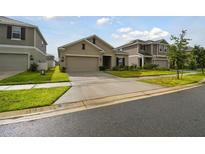 Tan two-car garage house with landscaping and driveway at 1122 James Paul Rd, Davenport, FL 33837